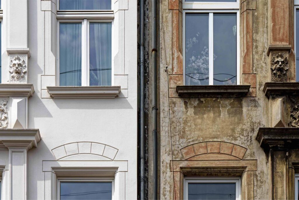 Neue versus sanierungsbedürftige Fassade einer Immobilie