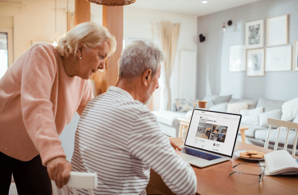 Altes Ehepaar schaut sich Immobilieninserate auf dem Laptop an