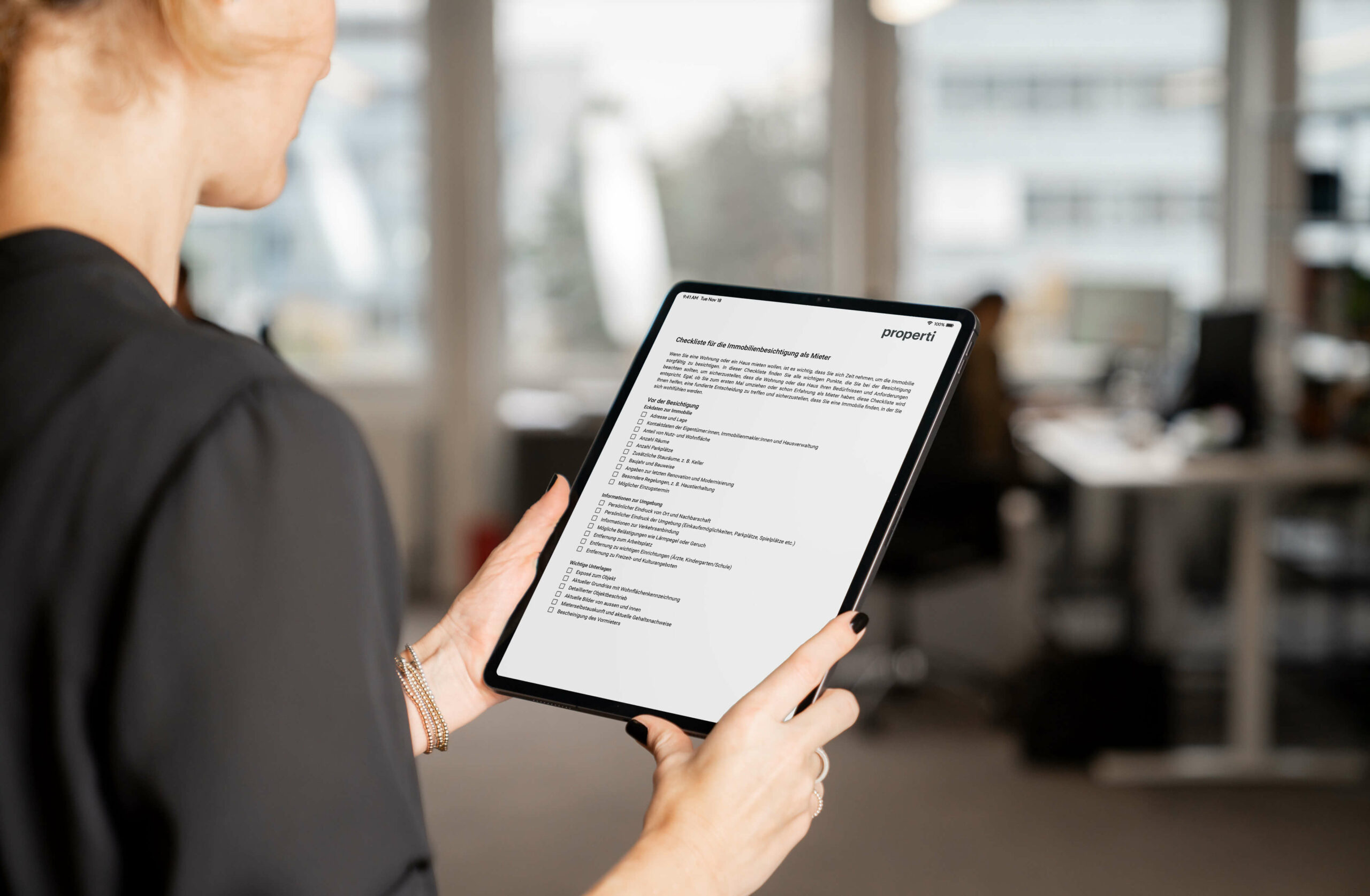 Eine Frau liest die properti Checkliste für die Immobilienbesichtigung als Mieter auf ihrem iPad