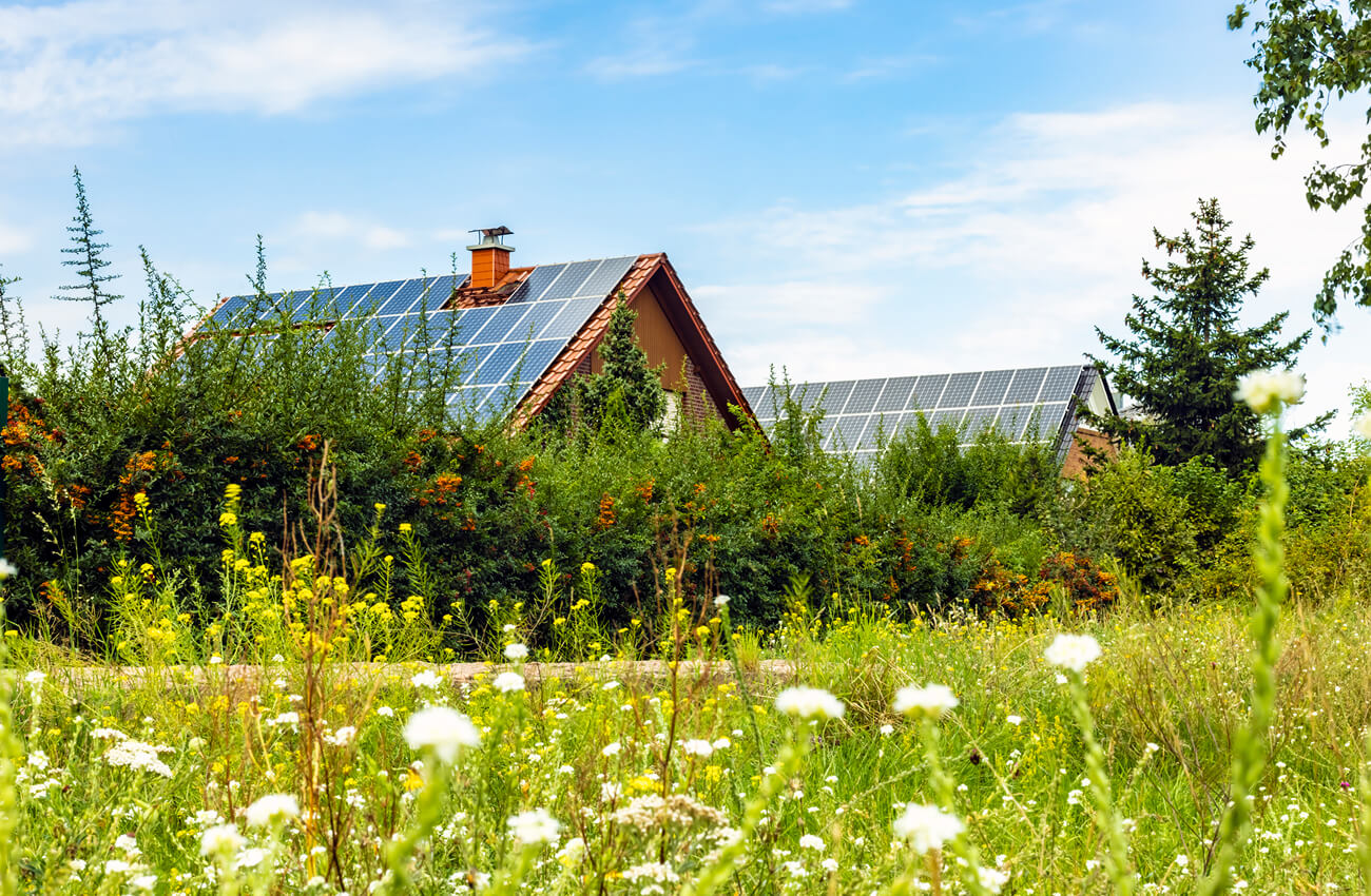 Houses with solar panels in green surroundings - a symbol of sustainable living and modern real estate standards