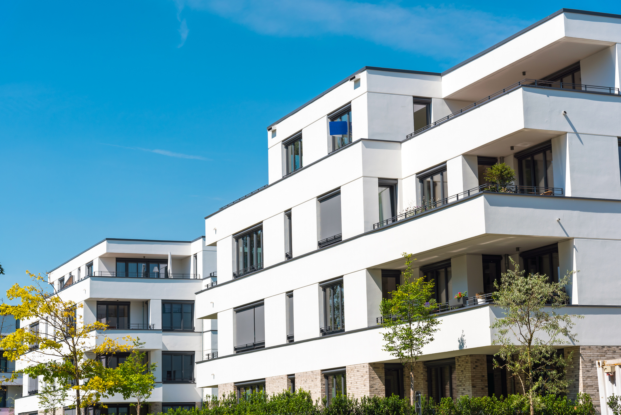properti Blog Header mit einem Schweizer Mietshaus mit Bergblick, Mietpreise 2025: Was der Referenzzinssatz bestimmt