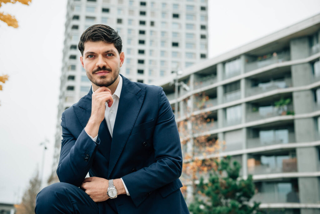L'agente immobiliare Luca Lauria davanti a moderni condomini a Zurigo.