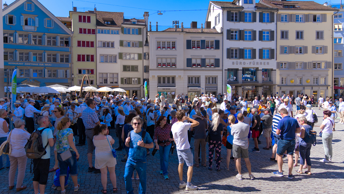 Menschen in einem Schweizer Stadtzentrum, die das Bevölkerungswachstum, die Wohnraumnachfrage und die Abstimmung zur 10-Millionen-Initiative in der Schweiz symbolisieren.